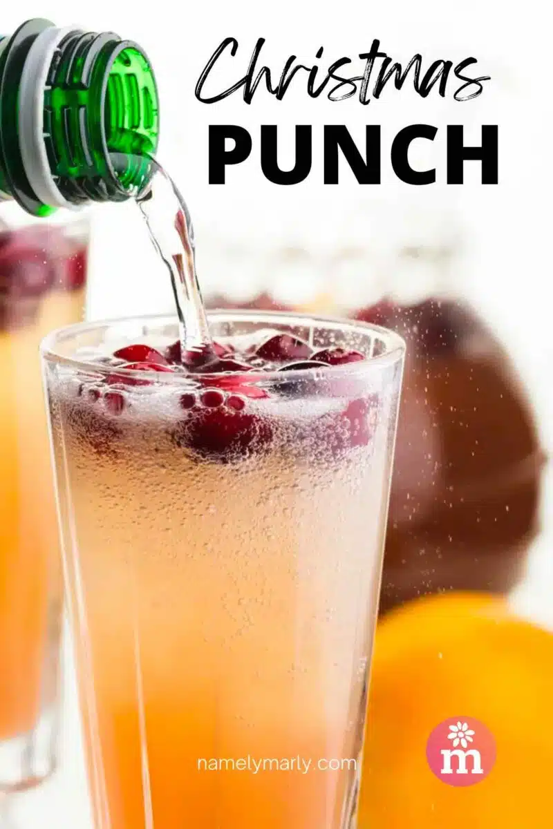 Sparkling water is being poured into a glass with punch and cranberries. The text reads, Christmas Punch.